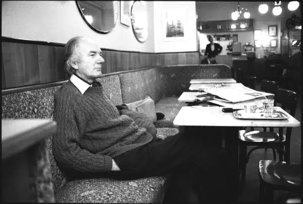 Tomas Bernhard u kafeu sa novinama na stolu